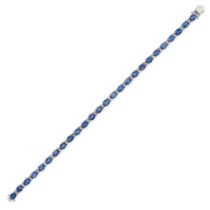 A SAPPHIRE AND DIAMOND LINE BRACELET in 18ct white gold, set with a row of oval cut sapphires, al...