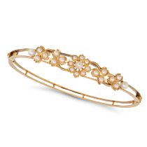AN ANTIQUE PEARL BANGLE in yellow gold, the hinged bangle in foliate design set with pearls, insc...