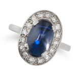 A SAPPHIRE AND DIAMOND CLUSTER RING in white gold, set with an oval cabochon sapphire of approxim...