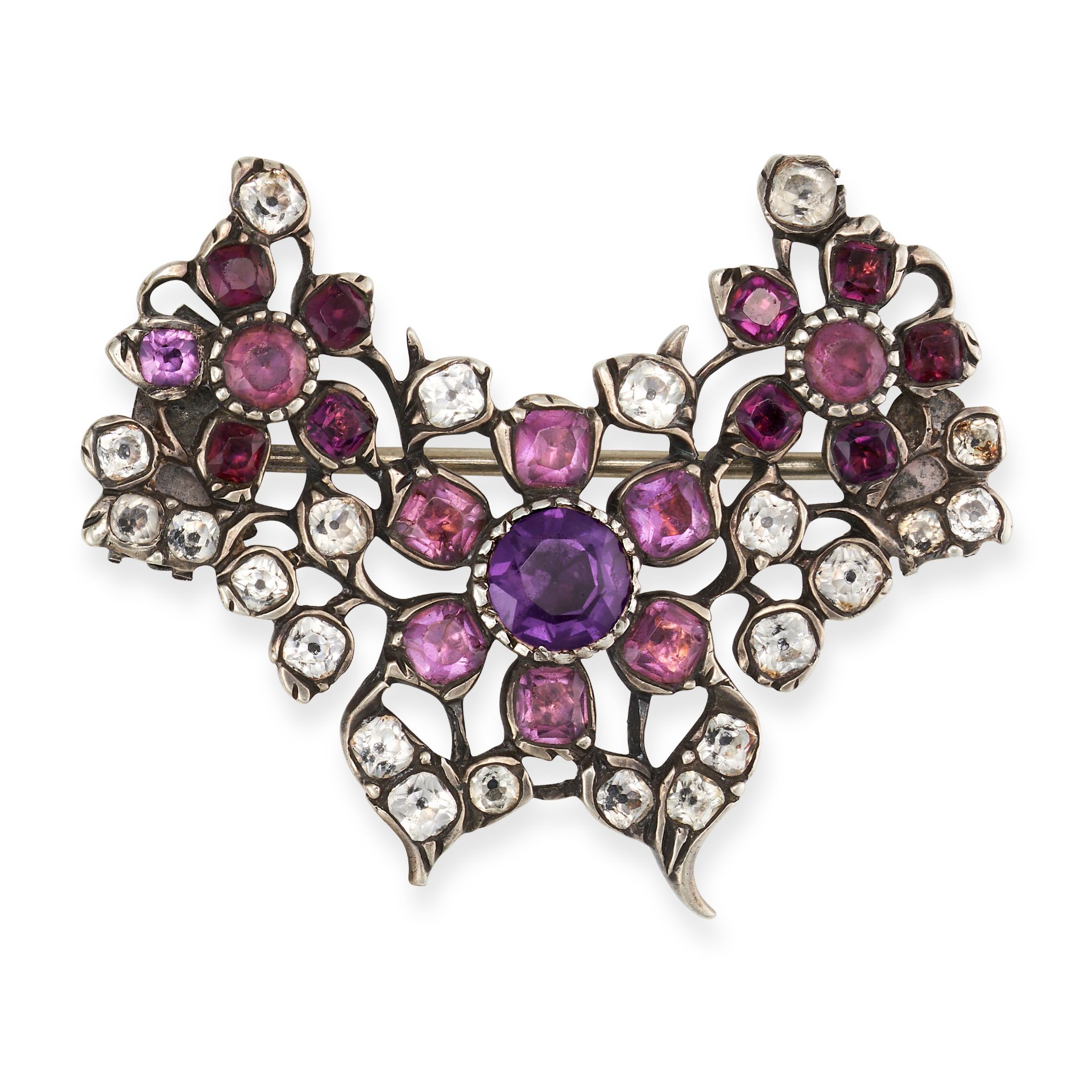 AN ANTIQUE PASTE BROOCH in silver, the foliate brooch set with oval and cushion cut purple paste ...