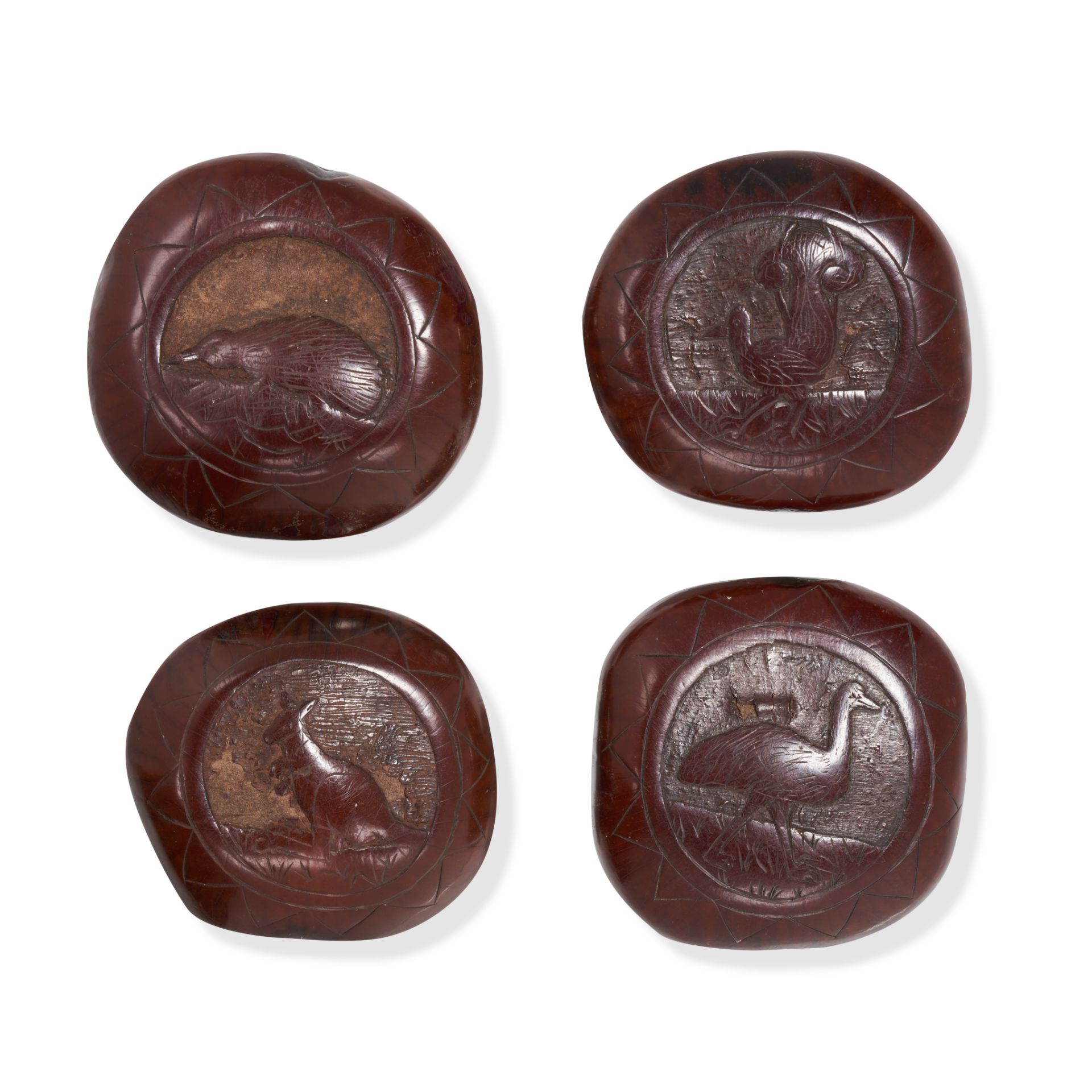 A SET OF FOUR AUSTRALIAN CARVED NUT BUTTONS each carved with an indigenous animal including an em...