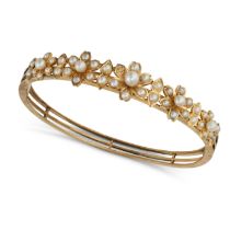 AN ANTIQUE PEARL BANGLE in yellow gold, the hinged bangle comprising a row of foliate motifs set ...