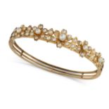 AN ANTIQUE PEARL BANGLE in yellow gold, the hinged bangle comprising a row of foliate motifs set ...
