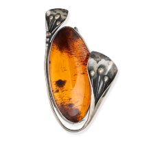 NO RESERVE - AN AMBER BROOCH in silver, set with a large cabochon amber in a stylised silver foli...