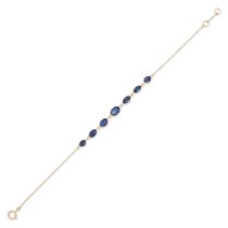 A SAPPHIRE BRACELET in 18ct yellow gold, comprising a trace chain set with seven oval cut sapphir...