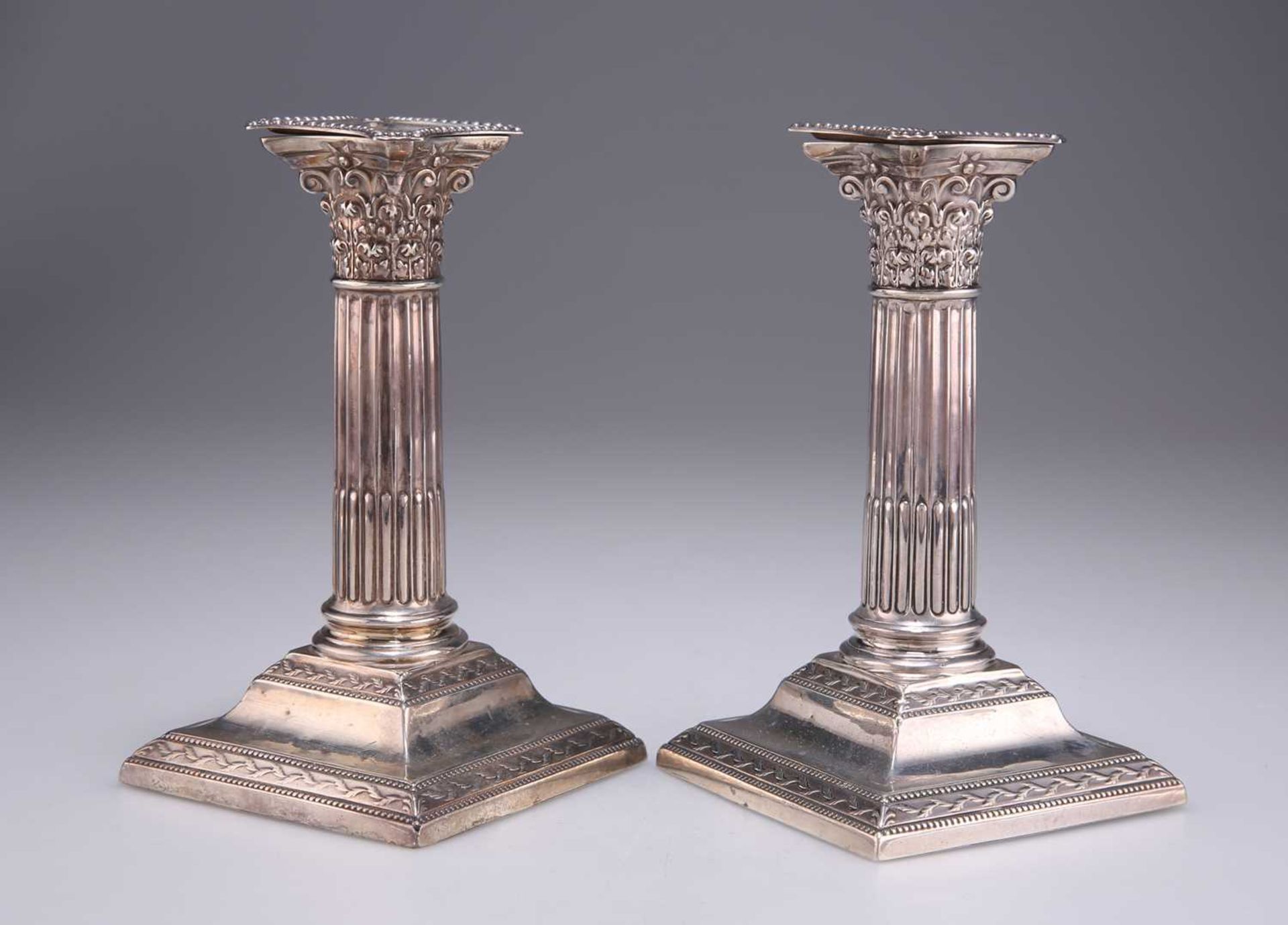 A PAIR OF LATE VICTORIAN SILVER CORINTHIAN COLUMN CANDLESTICKS