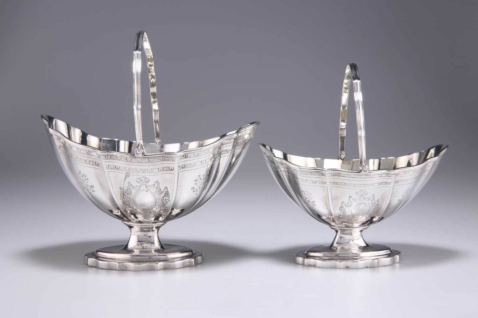 A GRADUATED PAIR OF GEORGE III SILVER SWING-HANDLED SUGAR BASKETS - Image 2 of 3