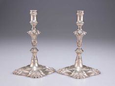 A PAIR OF GEORGE II CAST SILVER TAPERSTICKS