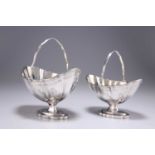 A GRADUATED PAIR OF GEORGE III SILVER SWING-HANDLED SUGAR BASKETS