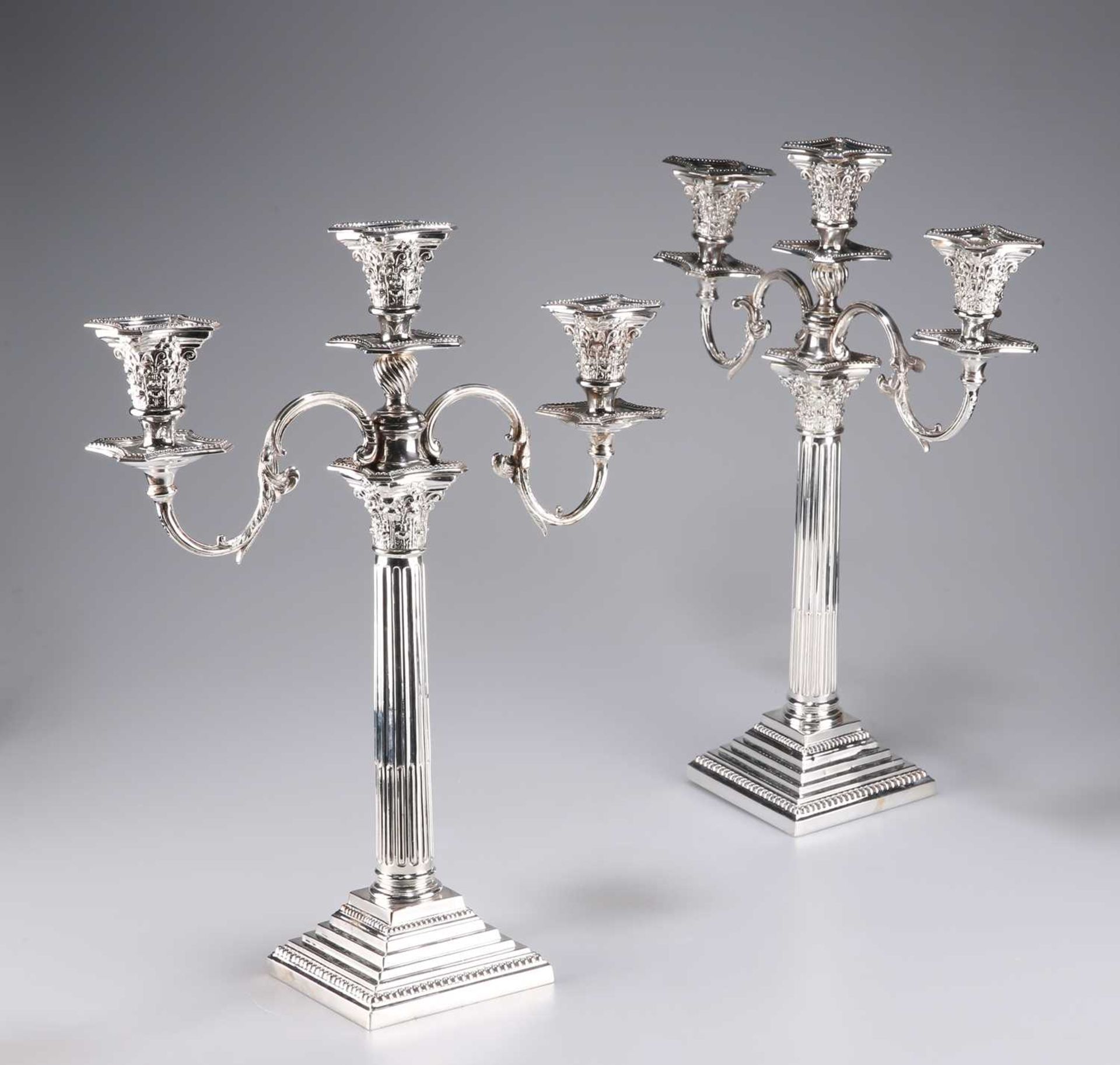 A PAIR OF VICTORIAN SILVER-PLATED CORINTHIAN COLUMN CANDELABRA