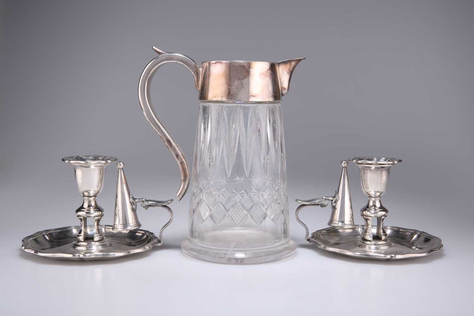 A VICTORIAN SILVER-PLATE MOUNTED CUT-GLASS LEMONADE JUG, AND A PAIR OF ELECTRO-PLATED CHAMBERTICKS