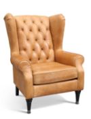 A BROWN LEATHER UPHOLSTERED WING-BACK ARMCHAIR