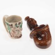 AN EARLY 19TH CENTURY PEARLWARE BACCHUS MASK MUG, AND LATE 19TH CENTURY TREACLE-GLAZED SPIRIT FLASK