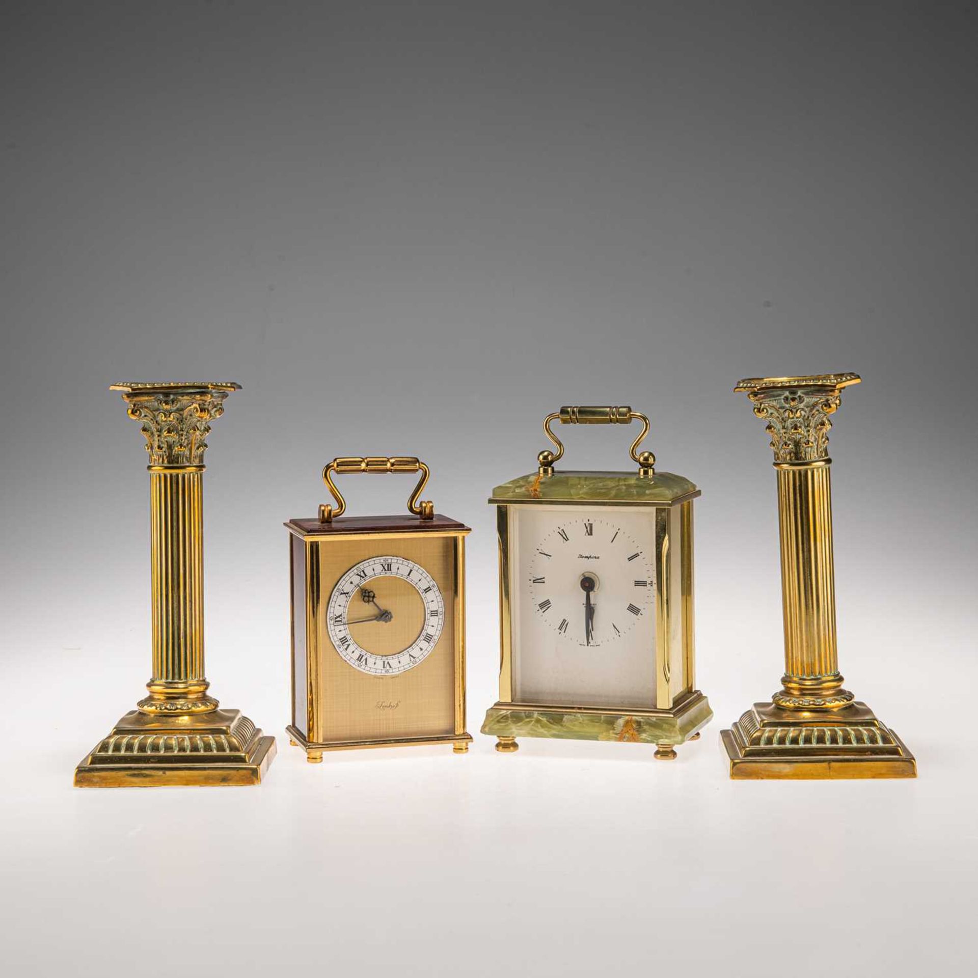 TWO CARRIAGE CLOCKS, AND A PAIR OF BRASS CORINTHIAN COLUMN CANDLESTICKS