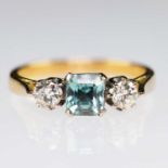 AN 18 CARAT GOLD BLUE ZIRCON AND DIAMOND THREE STONE RING