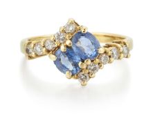 AN 18 CARAT GOLD SAPPHIRE AND DIAMOND CROSSOVER RING