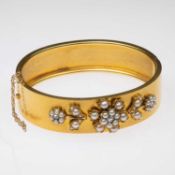 A LATE VICTORIAN DIAMOND AND SPLIT PEARL HINGE OPENING BANGLE