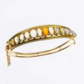 AN EARLY 20TH CENTURY OPAL HINGE OPENING BANGLE