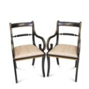 A PAIR OF REGENCY STYLE PARCEL-GILT AND EBONISED OPEN ARMCHAIRS