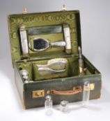AN EDWARDIAN HARRODS GREEN LEATHER VANITY CASE CONTAINING SILVER-MOUNTED DRESSING TABLE ARTICLES