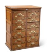 AN EARLY 20TH CENTURY OAK BANK OF DRAWERS, BY J. TAYLOR