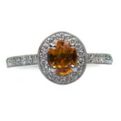 AN 18 CARAT WHITE GOLD YELLOW SAPPHIRE AND DIAMOND CLUSTER RING
