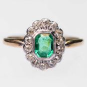 AN EARLY 20TH CENTURY EMERALD AND DIAMOND CLUSTER RING