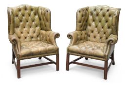 A PAIR OF GEORGIAN STYLE GREEN LEATHER AND MAHOGANY WING-BACK ARMCHAIRS