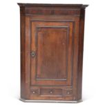 A GEORGE III OAK AND MAHOGANY HANGING CORNER CUPBOARD