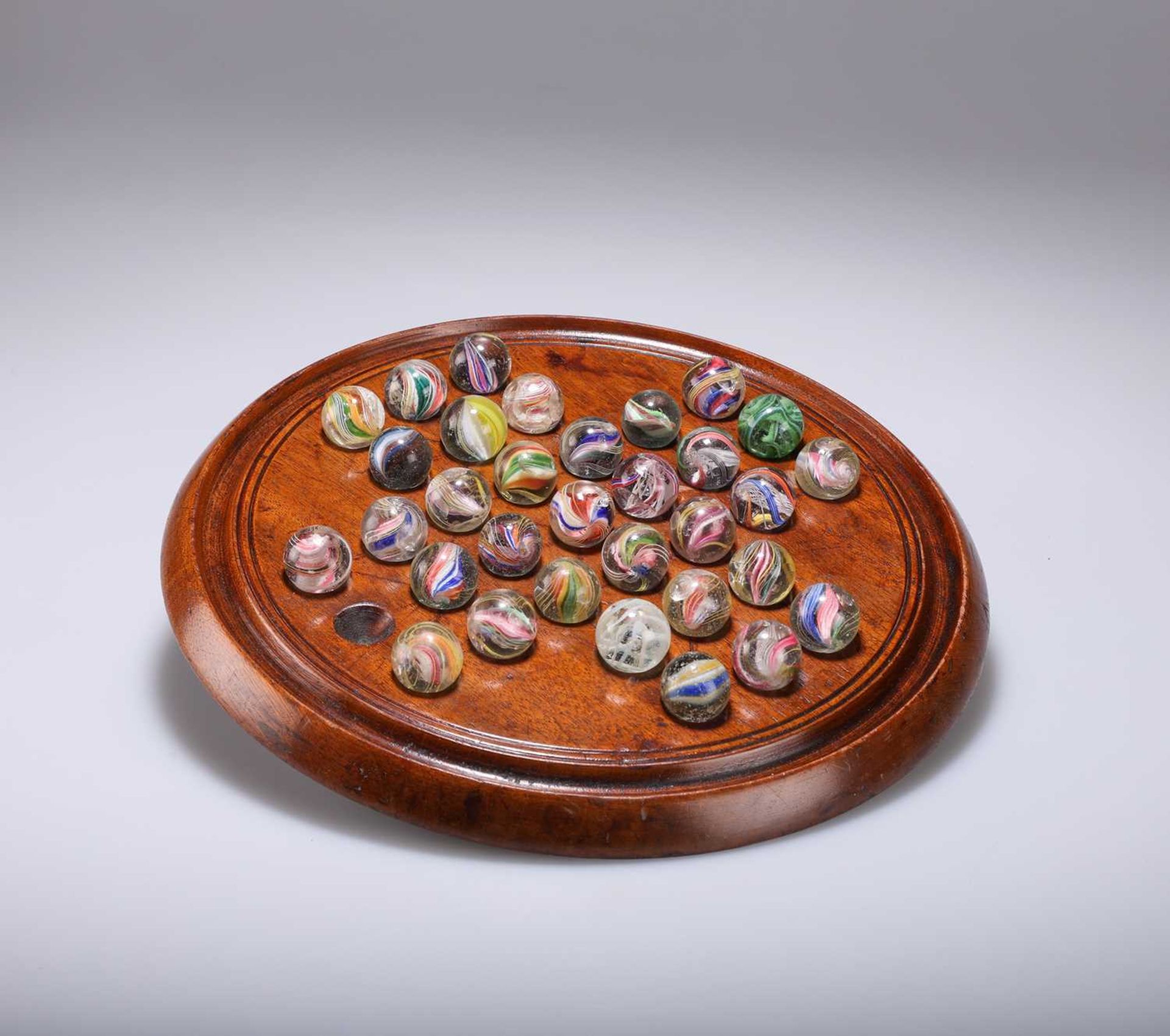 TREEN: A LATE VICTORIAN MAHOGANY SOLITAIRE BOARD AND MARBLES