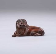 TREEN: AN EARLY 19TH CENTURY CARVING OF A RECUMBENT LION