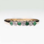 A 9 CARAT GOLD EMERALD AND DIAMOND HALF HOOP RING