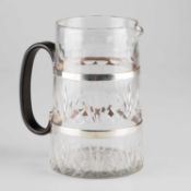 AN ART DECO SILVER AND BAKELITE-HANDLED CUT-GLASS WATER JUG