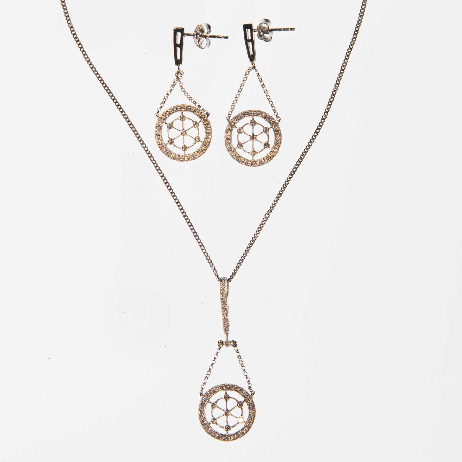 A DIAMOND PENDANT AND EARRING SET