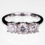 AN 18 CARAT WHITE GOLD DIAMOND THREE STONE RING