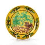 A CHINESE GREEN AND AUBERGINE-DECORATED YELLOW-GROUND SAUCER DISH