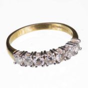 AN 18 CARAT YELLOW GOLD AND DIAMOND SEVEN STONE RING