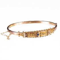 AN EDWARDIAN 9 CARAT YELLOW GOLD SAPPHIRE AND DIAMOND HINGED BANGLE