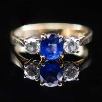 AN 18 CARAT YELLOW GOLD SAPPHIRE AND DIAMOND THREE STONE RING