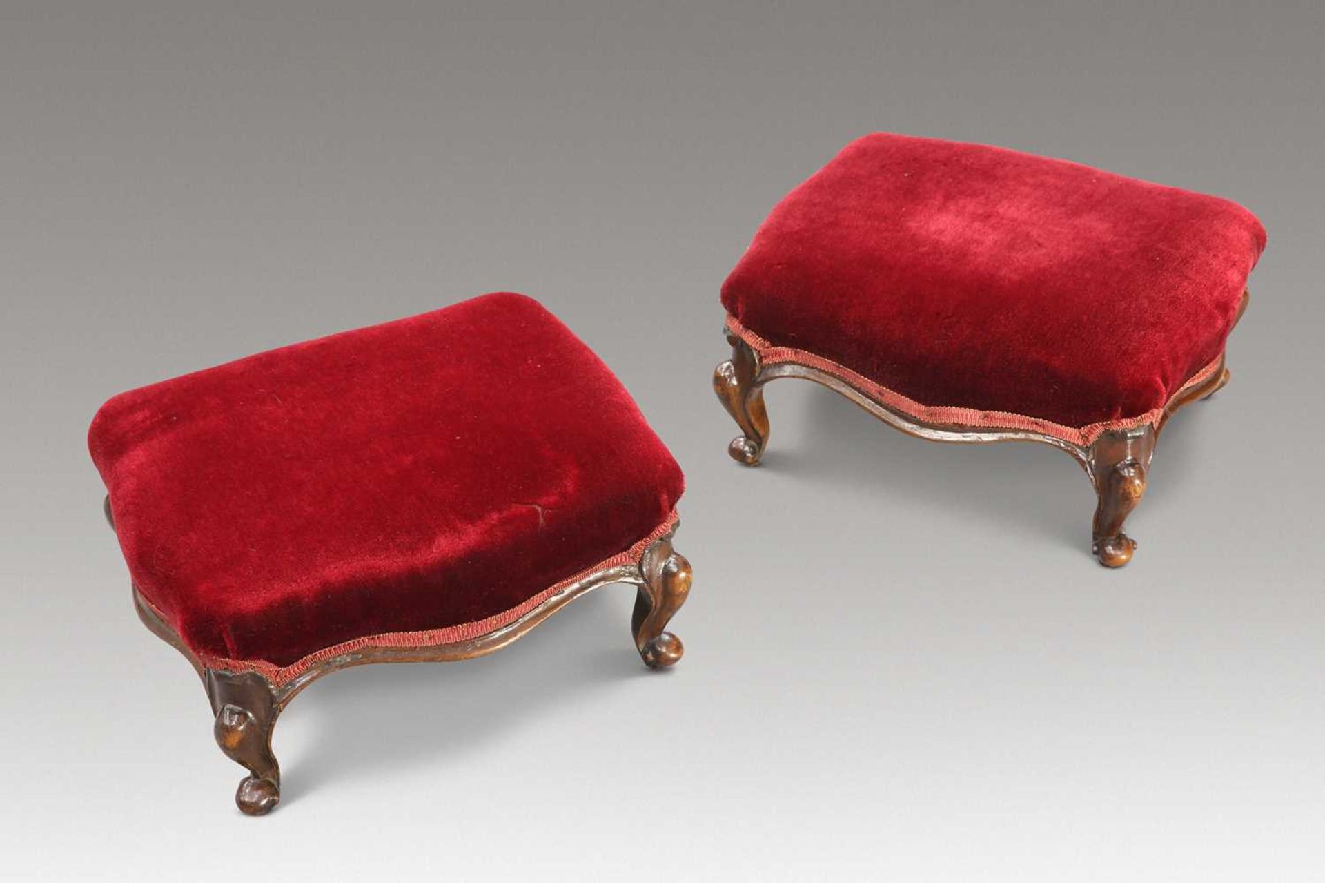 A PAIR OF VICTORIAN WALNUT AND UPHOLSTERED FOOTSTOOLS