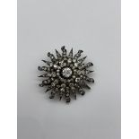 Diamond starburst brooch. The diamonds set in silv