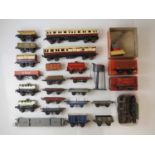 A mixed group of O gauge rolling stock comprising wagons and coaches by various manufacturers