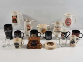 A collection of Guinness mugs, water jugs, glassware an ashtray etc.. Other beer related jugs and