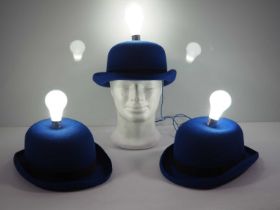 A group of three light-up bulb blue bowler hats by milliners Denton Hats, as worn during the