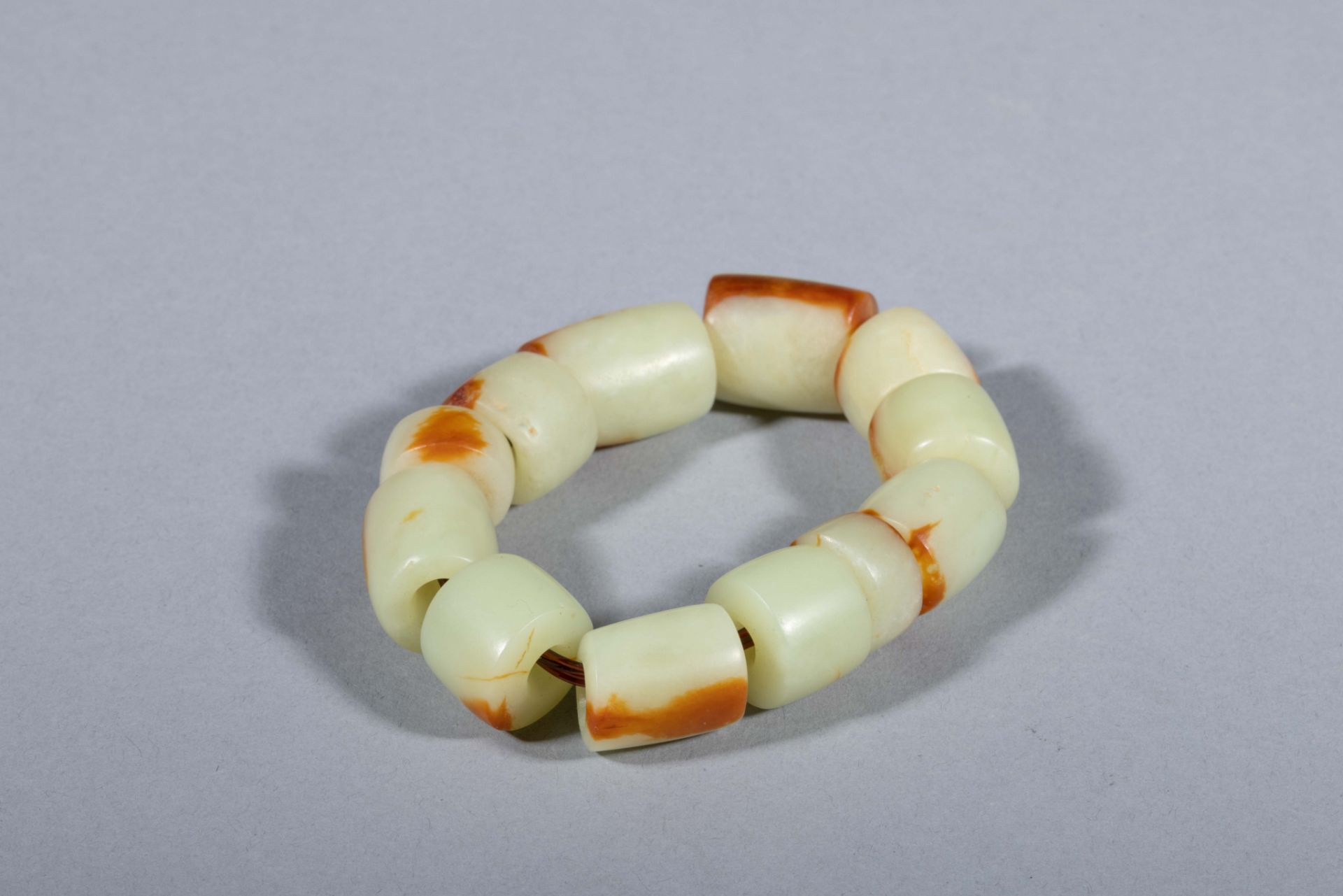Bracelet, composé de perles cylindriques Jade céladon nuancé de brun Chine Période, des Zhou de l’