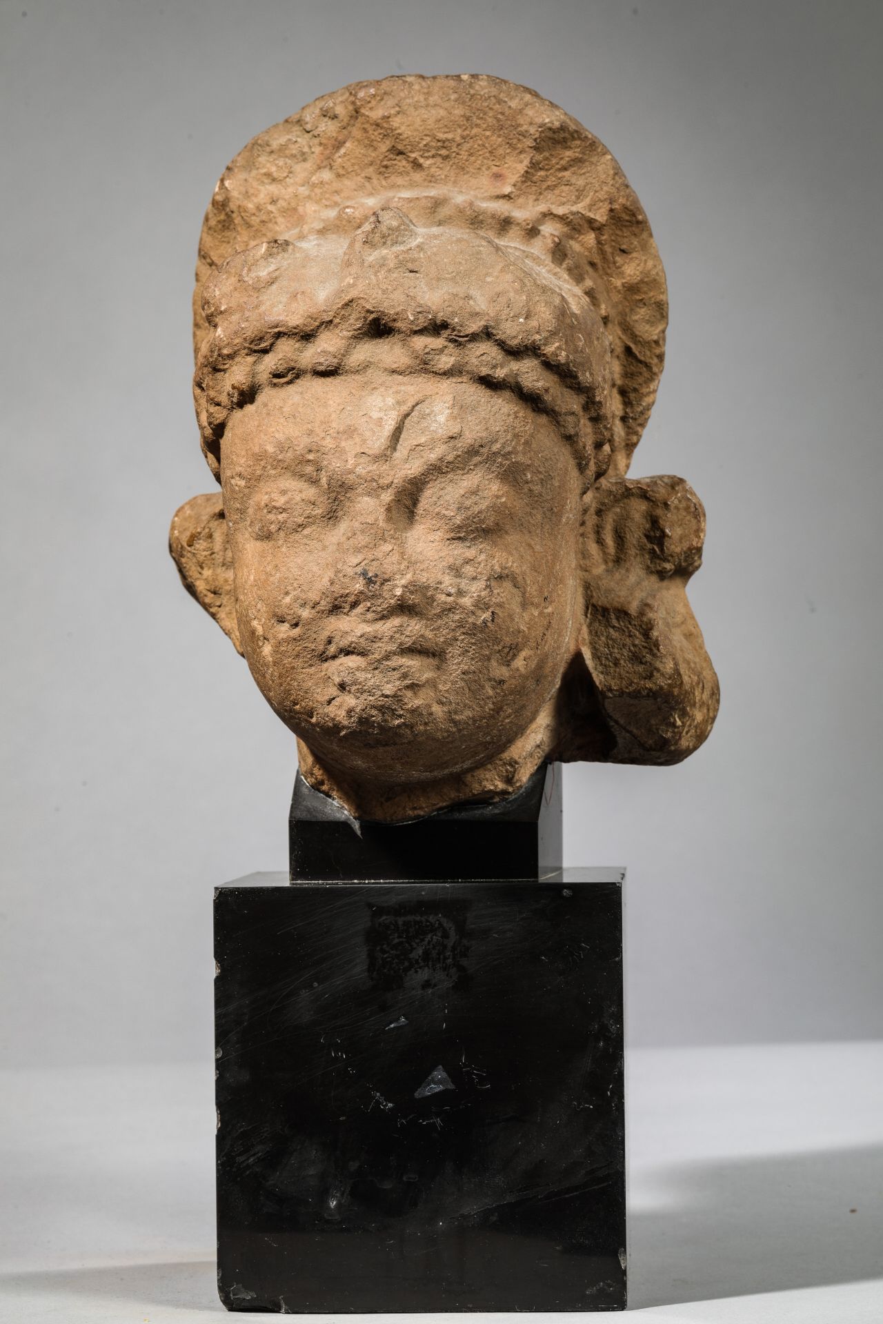 Tête de divinité féminine coiffée d’un chignon Pierre grès beige à patine du temps Inde dynastie