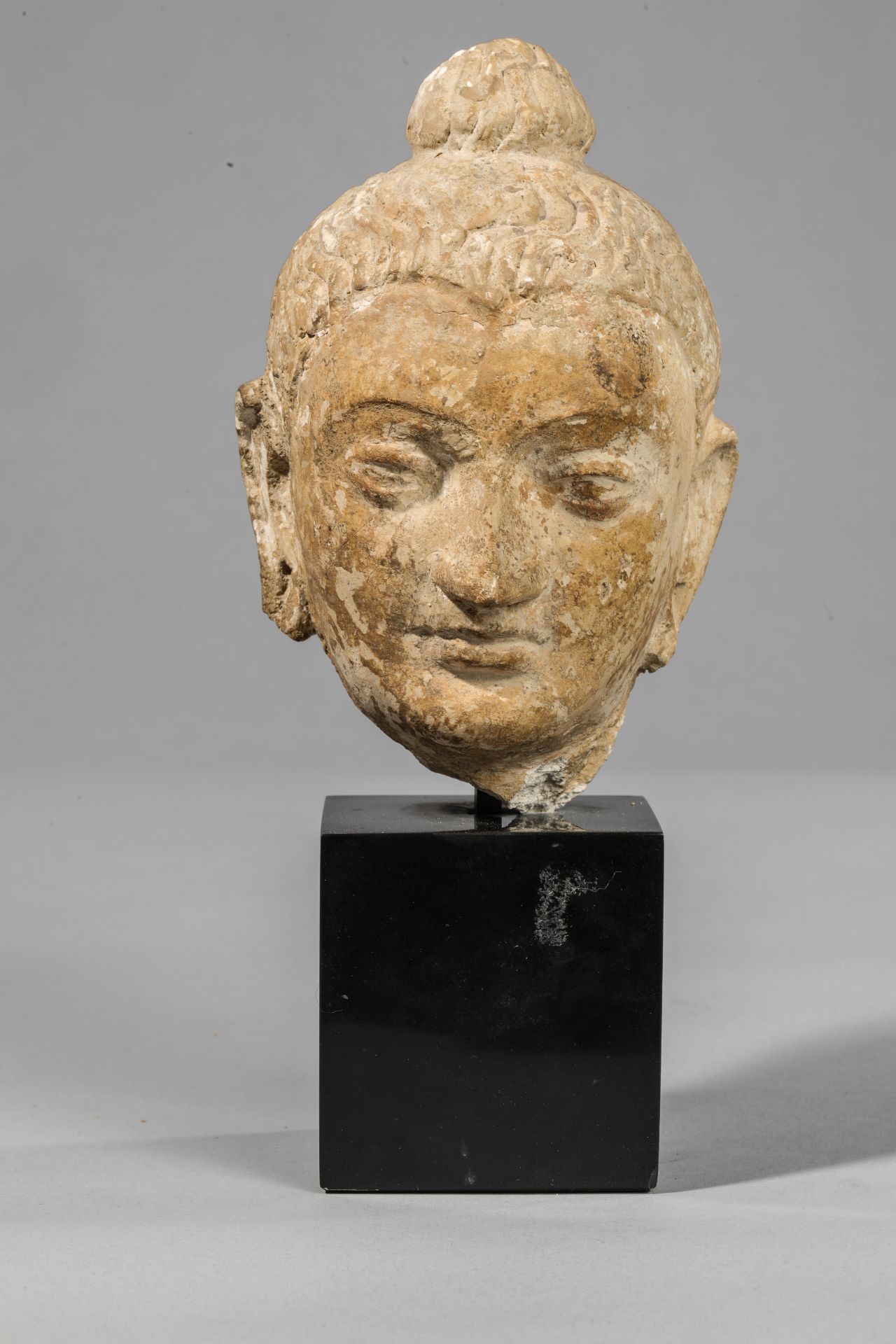 Tête du Boddhisattva Maitreya, coiffée d’une chevelure bouclée surmontée d’un chignon Stuc Art Gréco