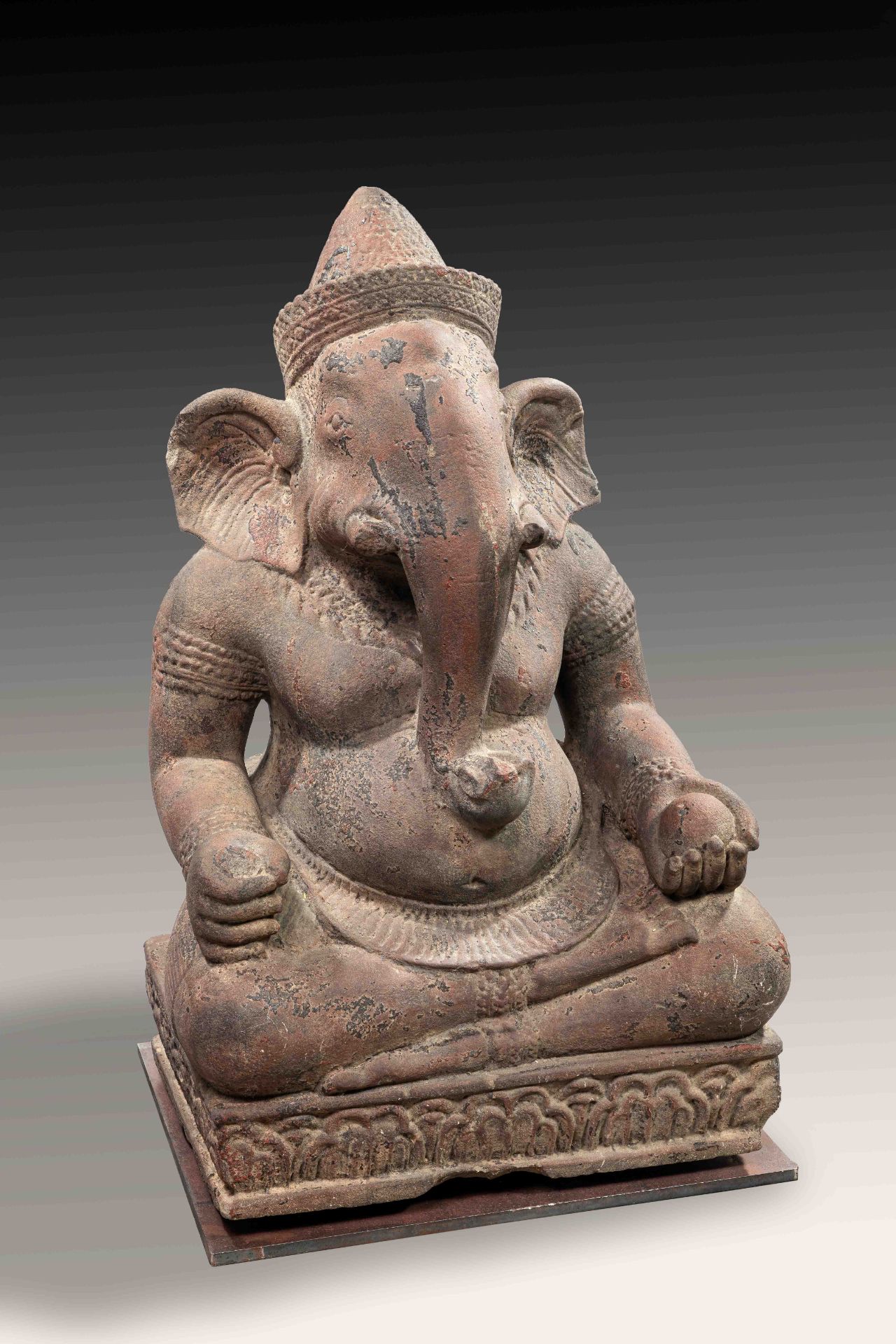 Ganesh assis en Virasana sur une base quadrangulaire lotiforme, ses deux mains posées sur ses