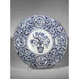 Large plat en porcelaine blanche décorée en bleu cobalt sous couverte d'un vase fleuri au centre