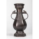Vase a corps hexagonal serti de larges anses à tête de chimère et moulé sur trois frises d'un